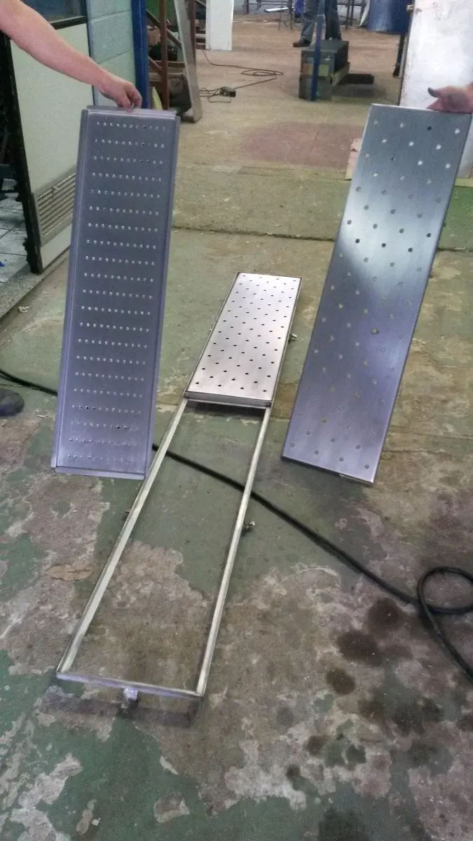 Peças de uma grelha de piso inox: grelha perfurada, camada filtrante e corpo do ralo linear